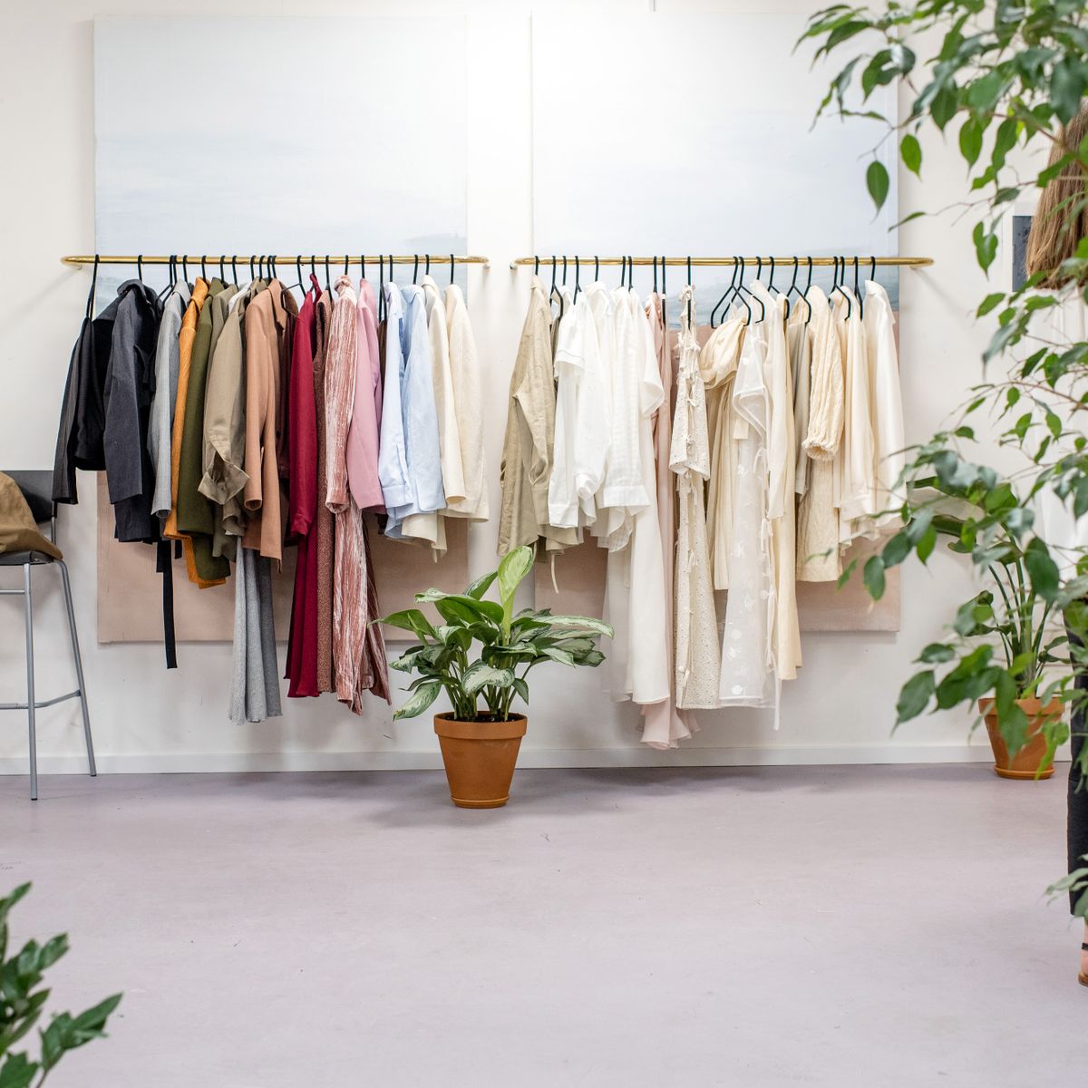 Rail of clothes in a bright room with plants