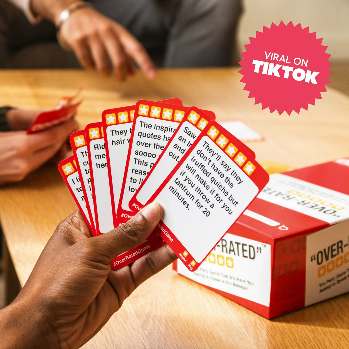 Hand fanning red review cards next to the game box with a viral on TikTok badge