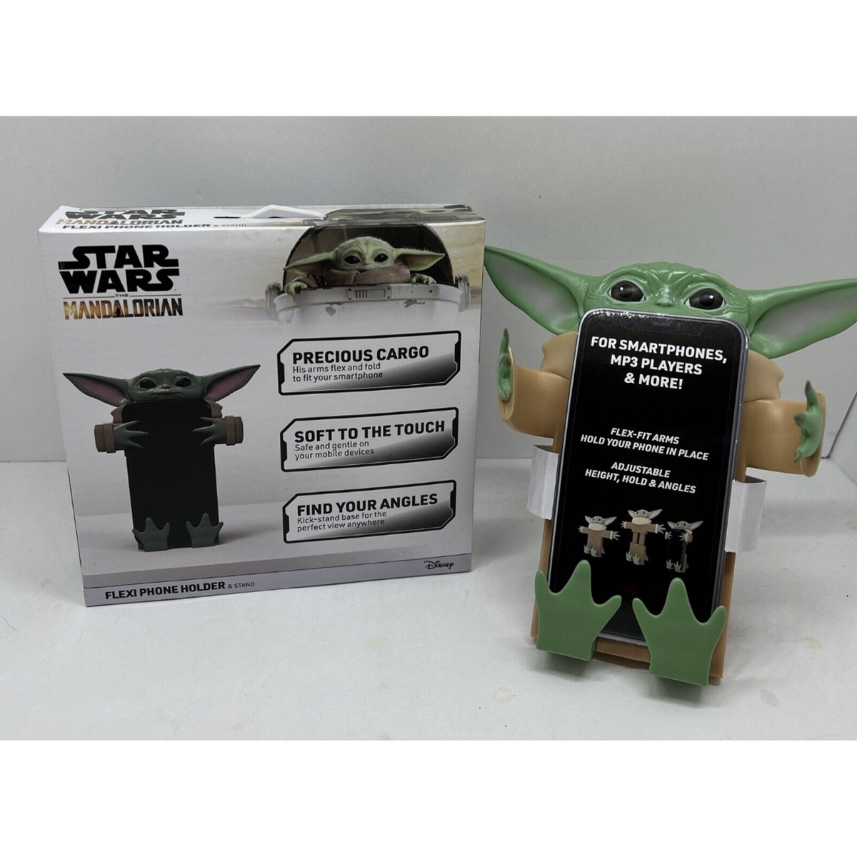 Grogu flexi phone holder hugging a phone beside its Star Wars Mandalorian box