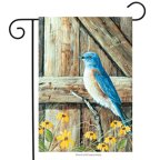 Garden flag with a bluebird perched on a weathered wooden gate among yellow flowers, on a stand