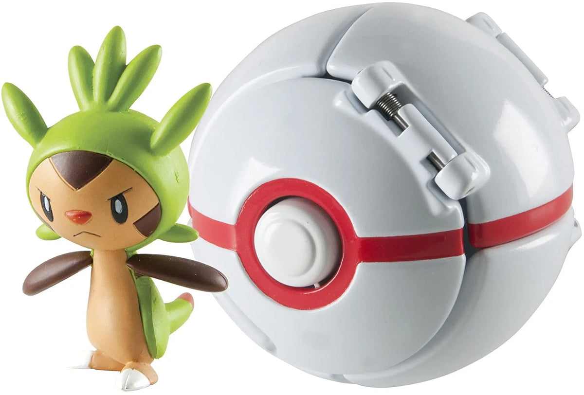 Green-headed grass creature figure beside a white capture ball with a red band