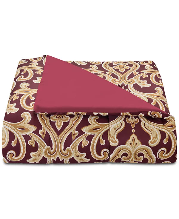 Folded comforter with burgundy gold damask side and solid red reverse turned back
