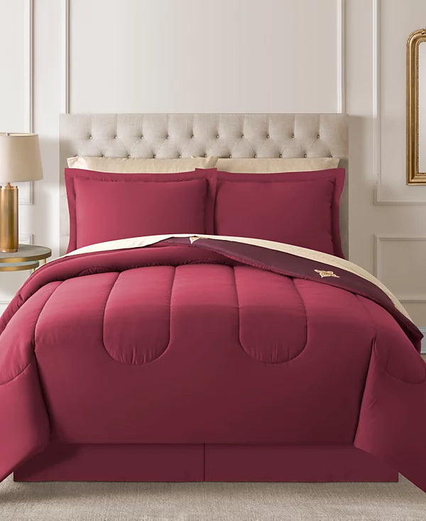 Comforter set flipped to the solid red reverse side on a tufted bed
