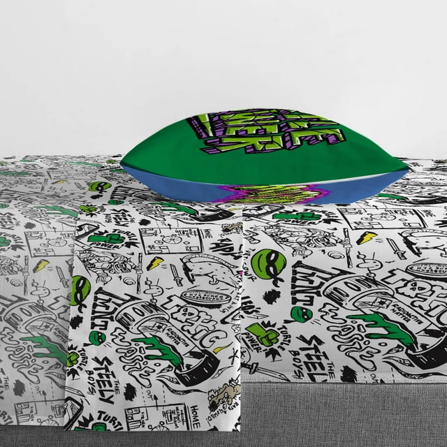 Close-up of the doodle-print sheet with the green and blue pillowcase on top