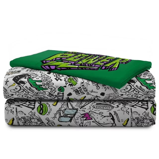 Folded doodle-print sheets topped with the green Turtle Power pillowcase