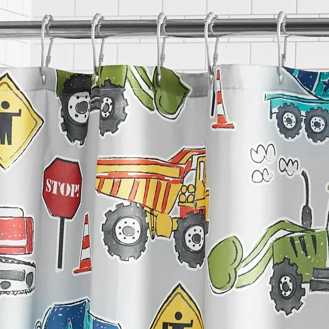 Hem of the grey curtain printed with trucks, cones and Slow signs