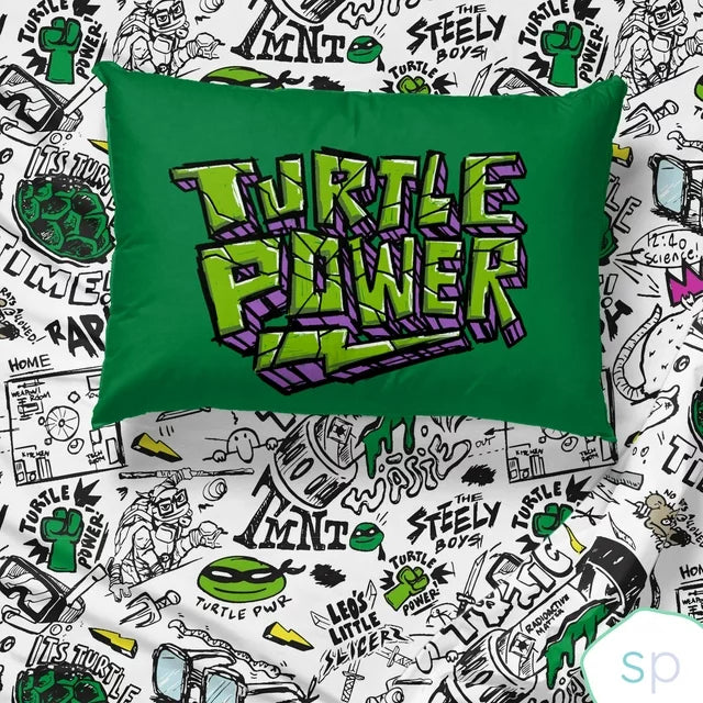Green Turtle Power pillowcase lying on the black and white doodle sheet