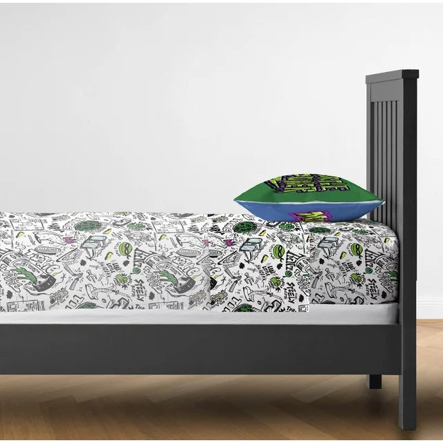 Side view of a dark bed made with the doodle sheets and green pillow