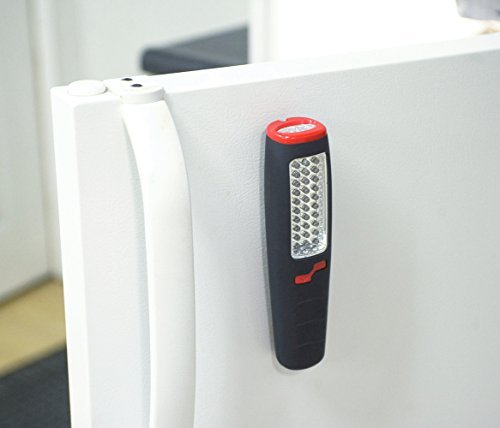 LED work light stuck by its magnet to the side of a white refrigerator