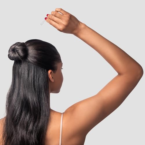 Woman with long dark hair in a half bun holding a hair pin