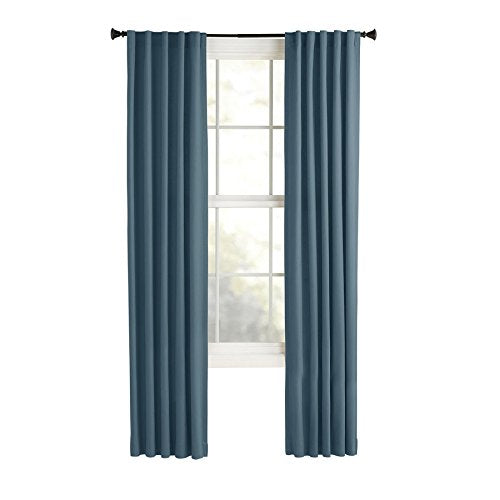 Two slate blue back tab curtain panels hanging on a dark rod beside a window