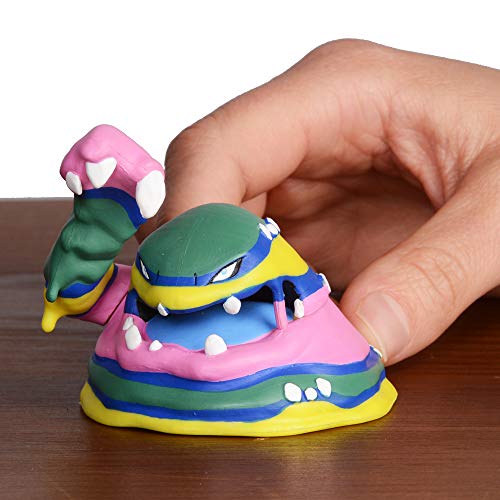 Hand holding the pink, green and yellow Muk figure for scale