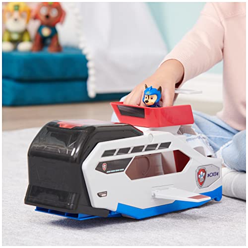 Child's hand placing the pup figure into the red seat on top of the whale vehicle