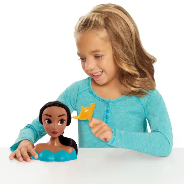 Smiling girl holding a gold lamp brush beside the dark-haired Jasmine styling head