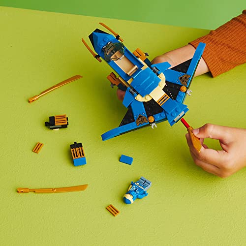 Child adding gold blade upgrades to the jet with the minifigure and spare parts nearby