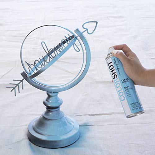 Hand spraying light blue paint onto a grey metal globe sculpture