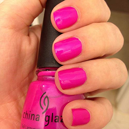 Hand with neon magenta purple nails holding the polish bottle