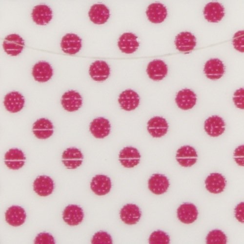 Close-up of white nail strip material with hot pink polka dots