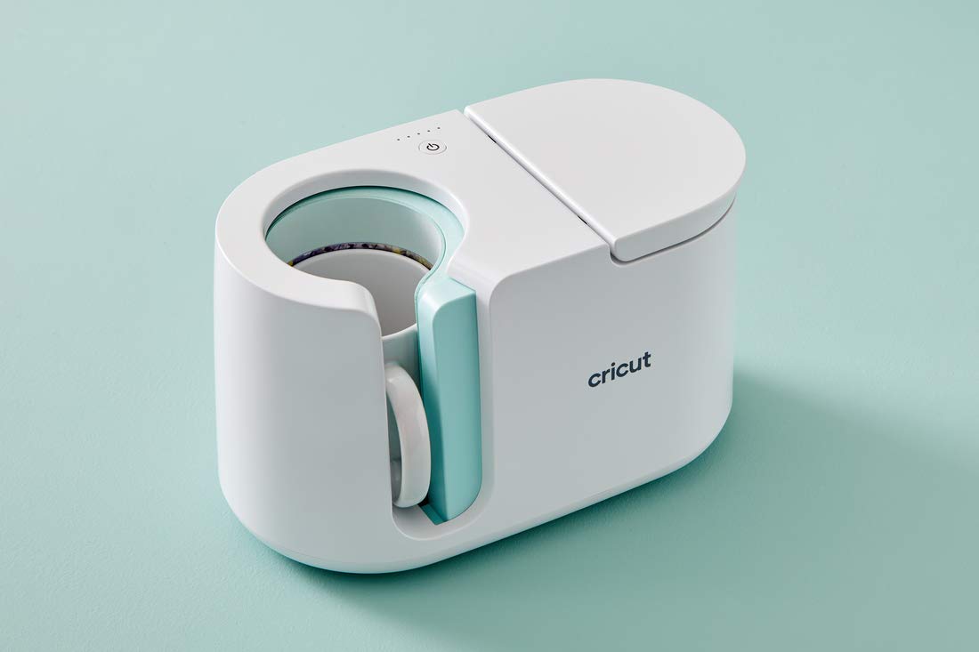 Cricut Mug Press with a mug inside the mint heat plate on a mint background
