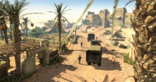 Gameplay scene of military trucks driving down a sandy road through a palm oasis