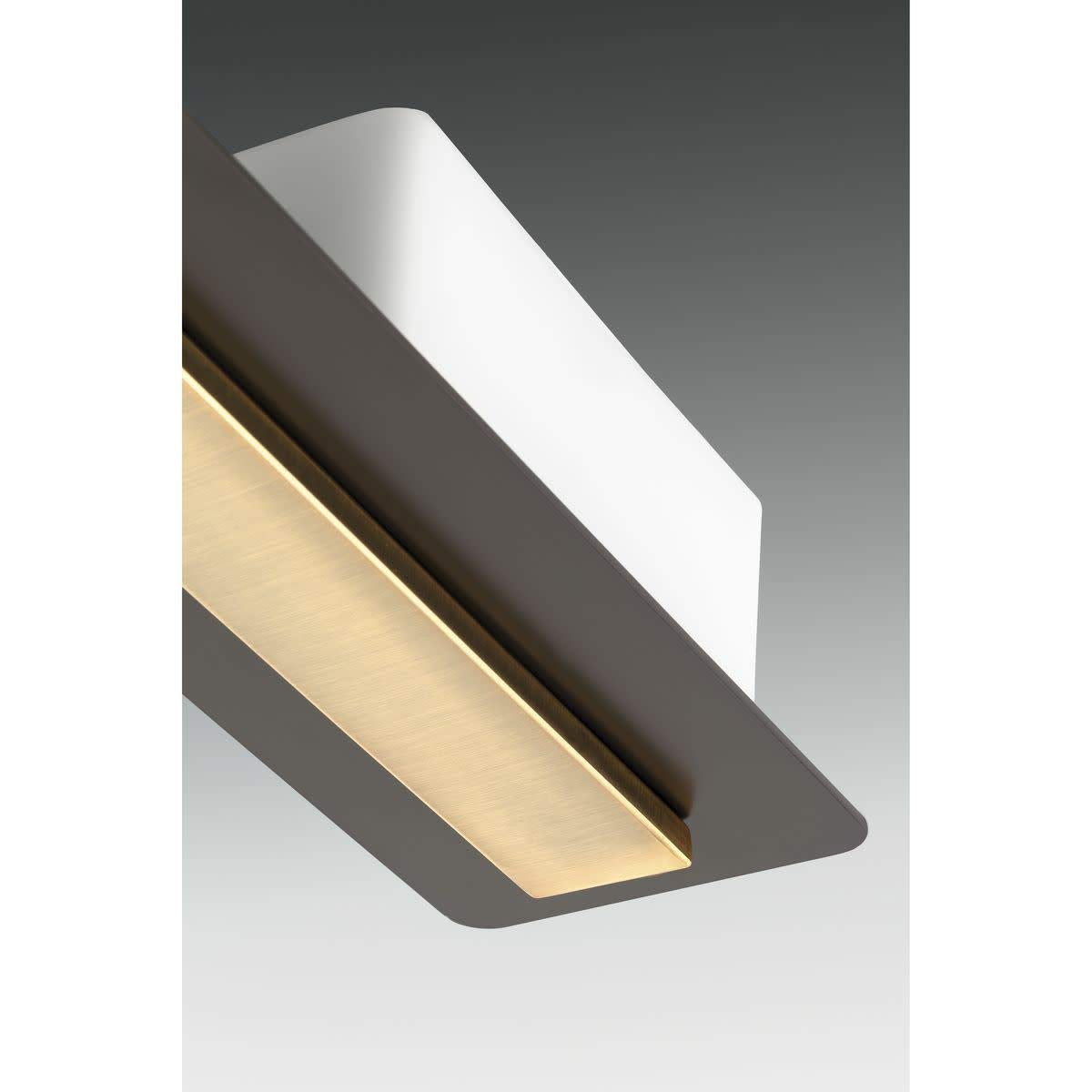 Angled view under the bath light arm showing the brushed brass inlay