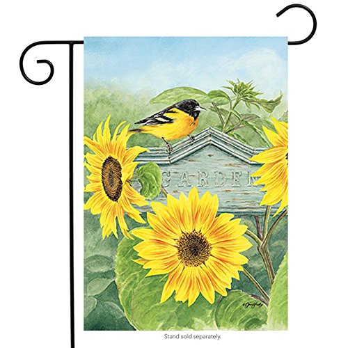 Garden flag with an oriole on a weathered Garden sign among yellow sunflowers, on a stand