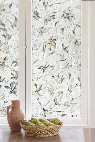 Window covered in frosted film with a pale iridescent leaf vine pattern
