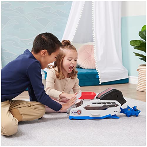 Two children playing with the whale team vehicle on a grey rug