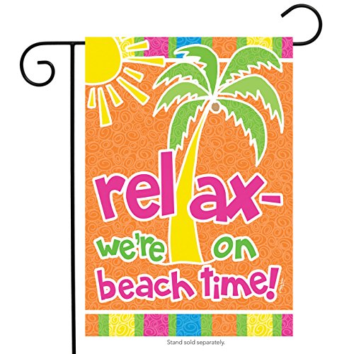 Orange garden flag with a palm tree and sun reading relax, we're on beach time, on a black stand