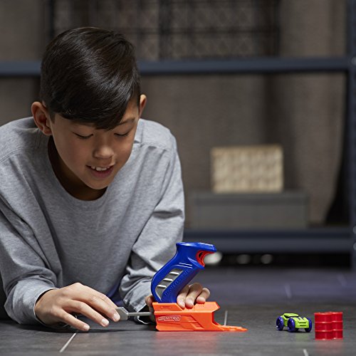 Boy pulling back the launcher's grey handle with the car and barrels ahead
