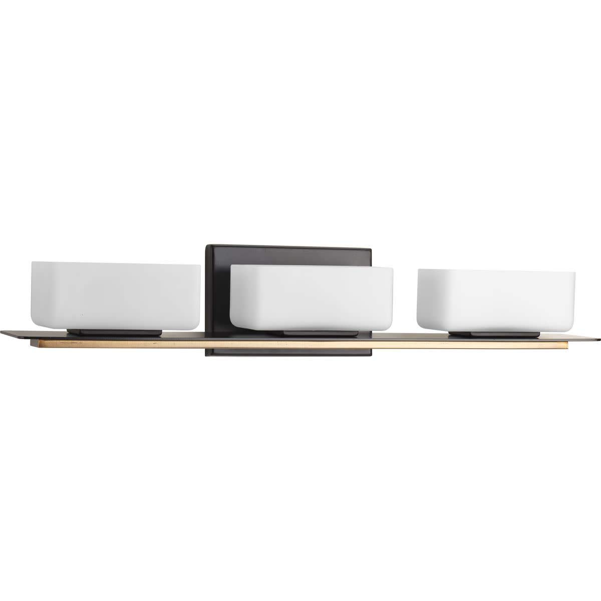Three-light bath bar with white rectangular glass shades on a dark bronze and brass backplate
