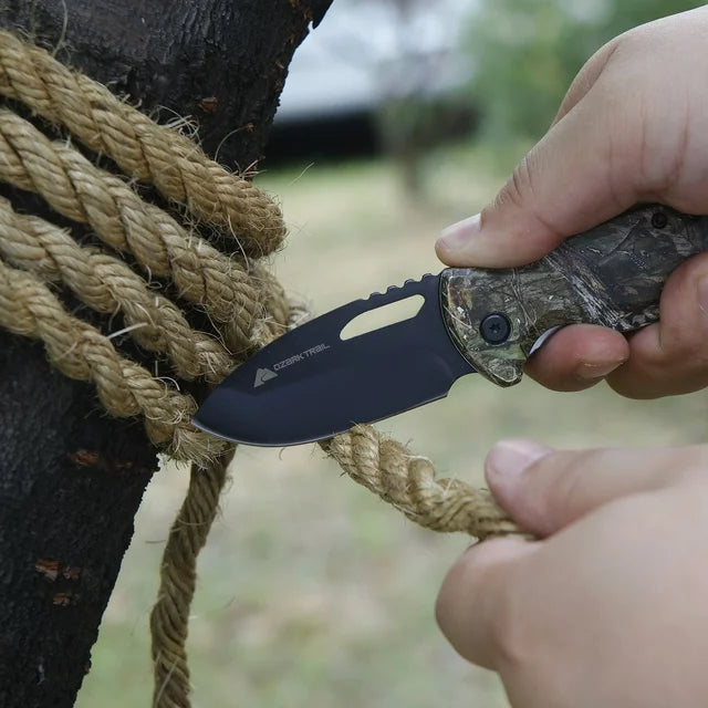 Hands cutting a thick rope tied around a tree with the camo knife