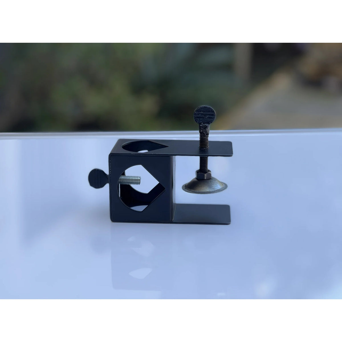 Side view of the black torch clamp with two thumbscrews and a round pad