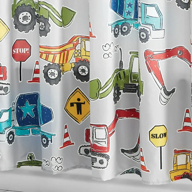 Grey kids' shower curtain with colorful construction vehicles in a white tiled bathroom