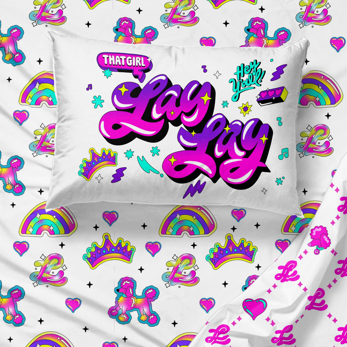 Close-up of the Lay Lay pillowcase over sheets with poodles, crowns and rainbows