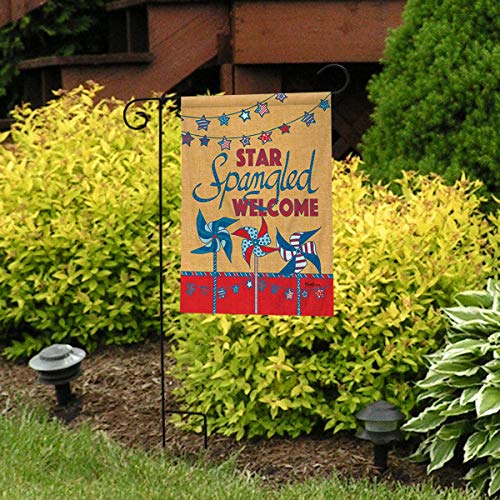 Star Spangled Welcome pinwheel flag on a stand in front of yellow shrubs
