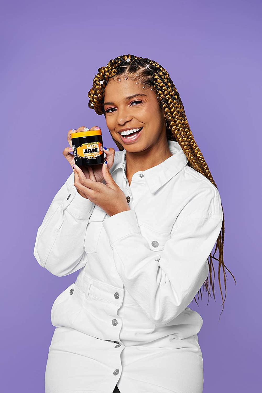 Smiling woman with long golden box braids holding a jar of the gel