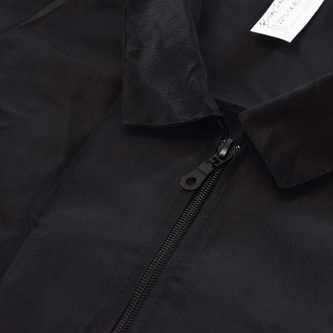 Close-up of the black barber jacket collar and zip pull