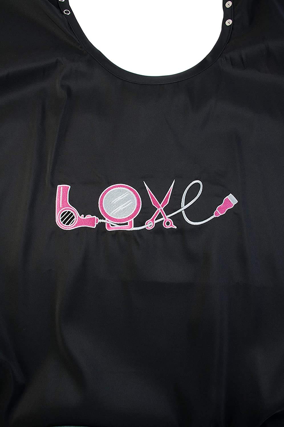 Close-up of the LOVE embroidery made of a pink hair dryer, mirror, scissors and clipper cord