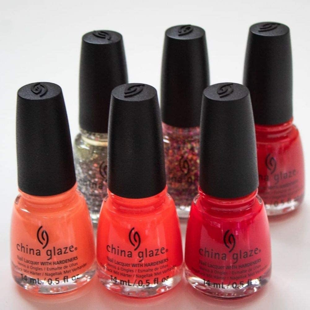 Six nail lacquer bottles in coral, red, pink and glitter shades with black caps