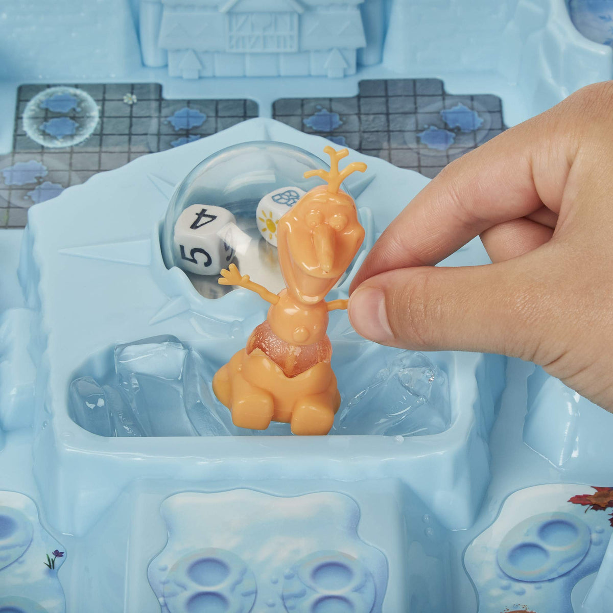 Hand holding an orange Olaf pawn with a melting ice body over the gameboard