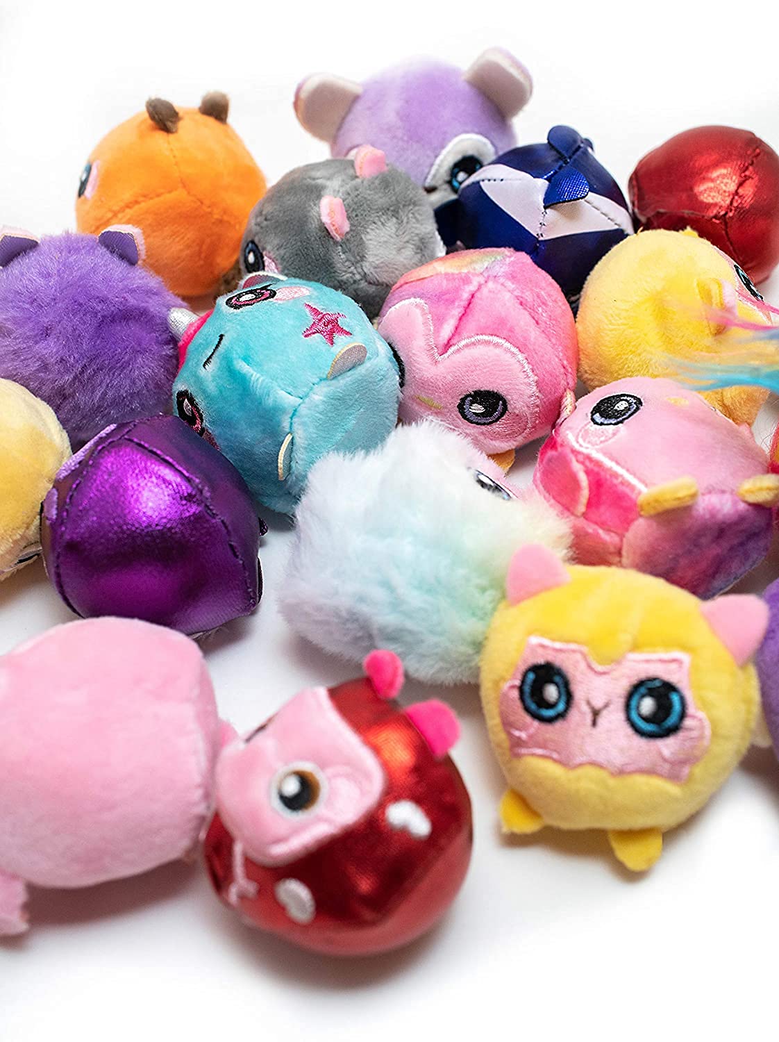 Close-up pile of tiny round plush animals in metallic and fluffy fabrics