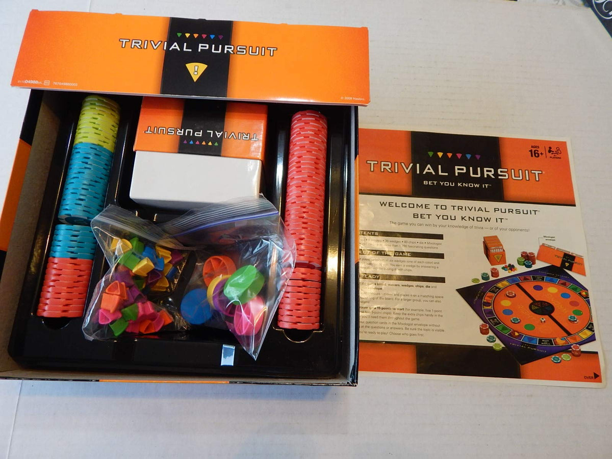 Open trivia game box with stacked chips, card box, bagged wedges and instruction sheet