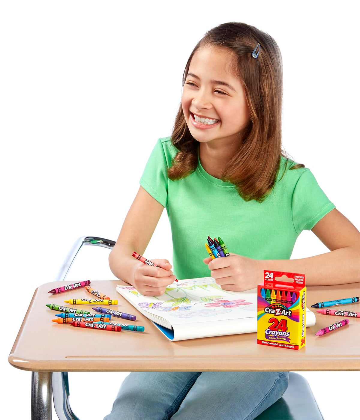 Smiling girl colouring flowers at a school desk with Cra-Z-Art crayons and the box