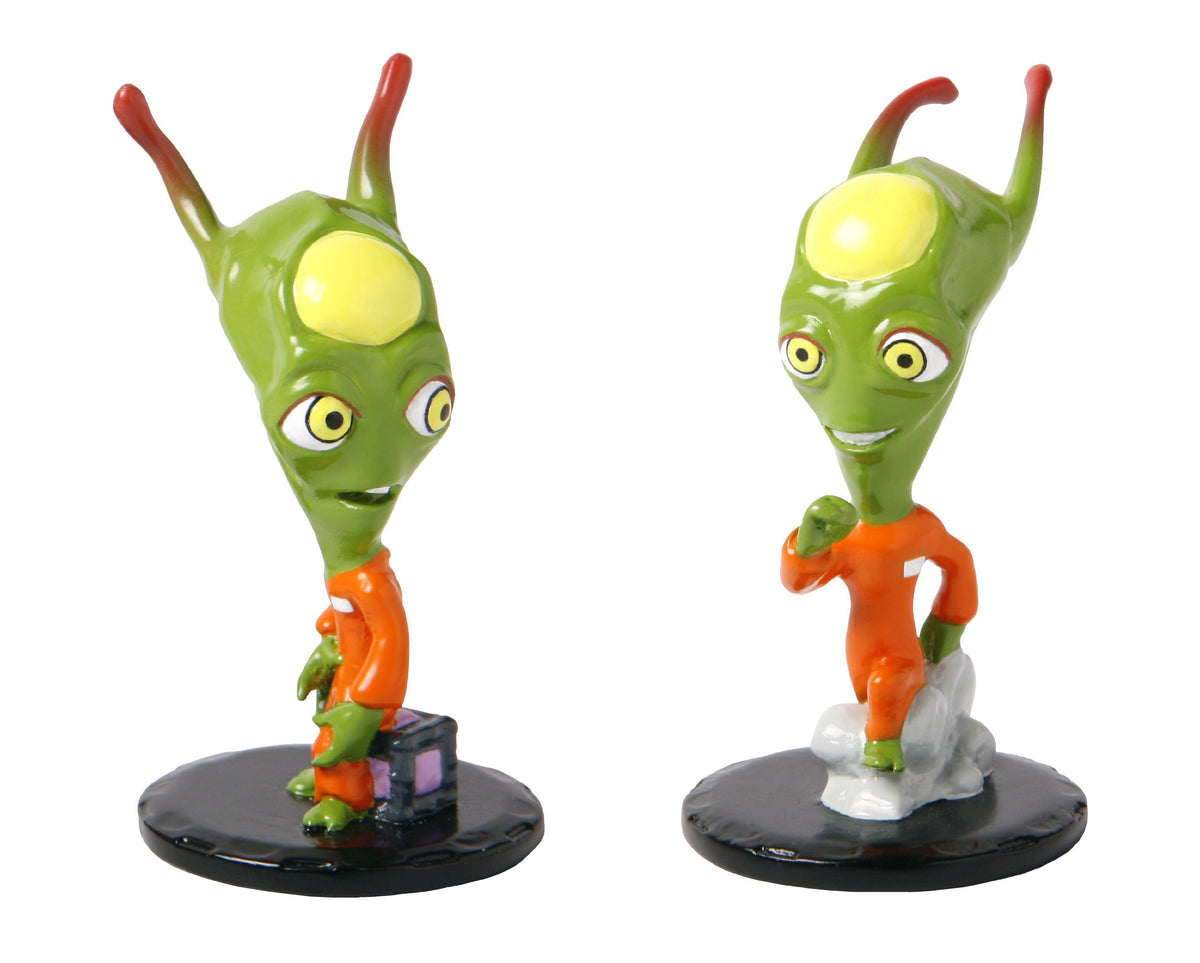 Two collectible green alien figures in orange prison jumpsuits on black bases