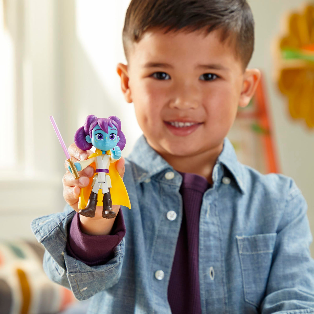 Boy holding the blue-skinned Jedi figure up close toward the camera