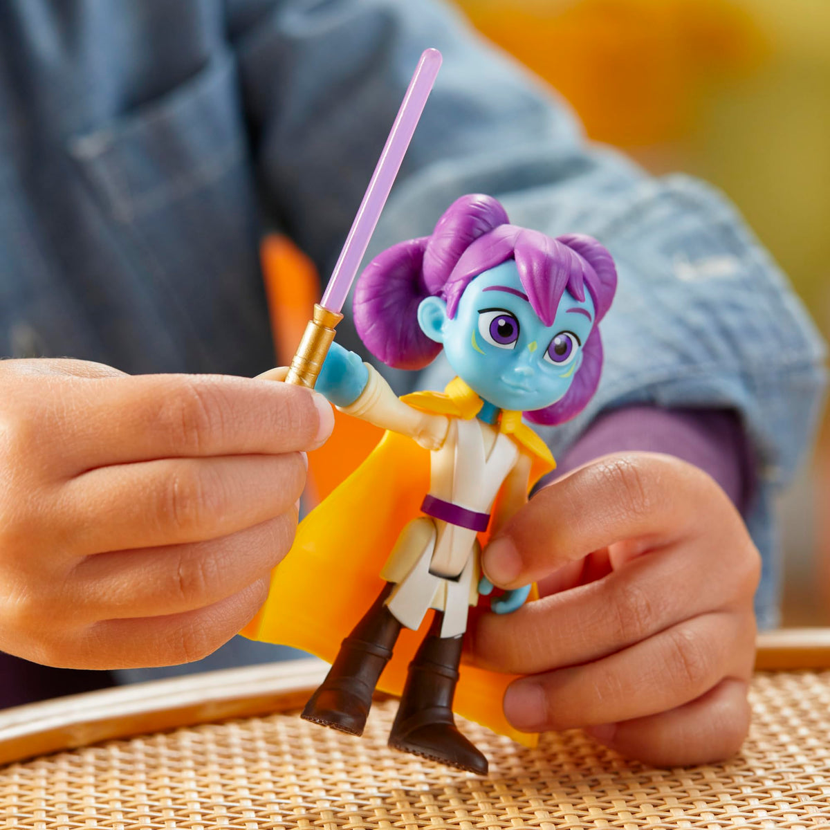 Child raising the purple lightsaber in the blue-skinned figure's hand