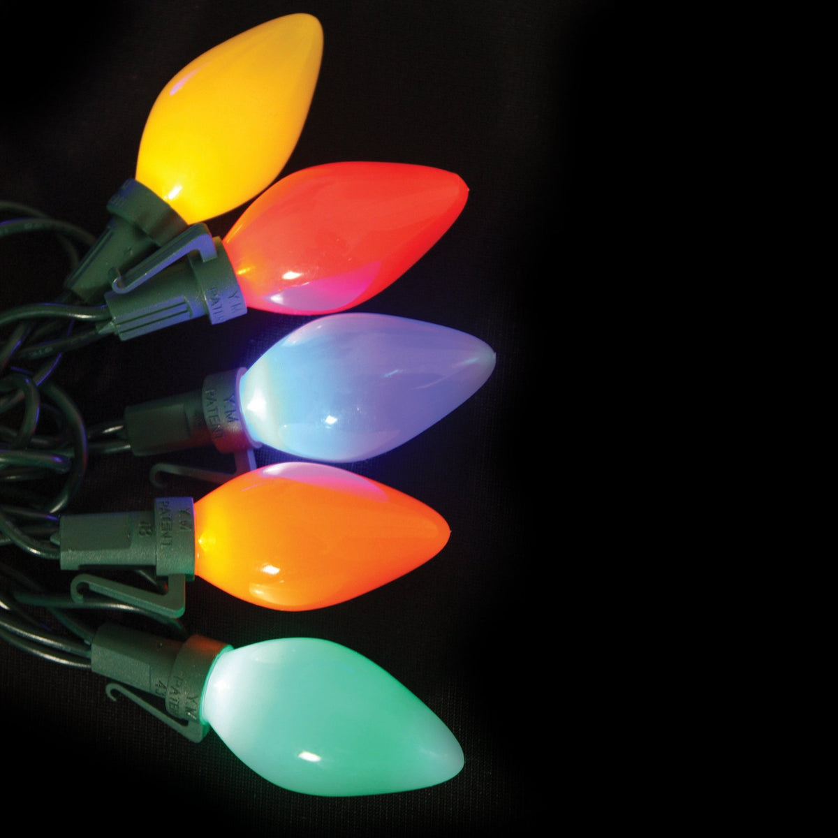 Multicolor C7 LED bulbs glowing on a green wire against a black background
