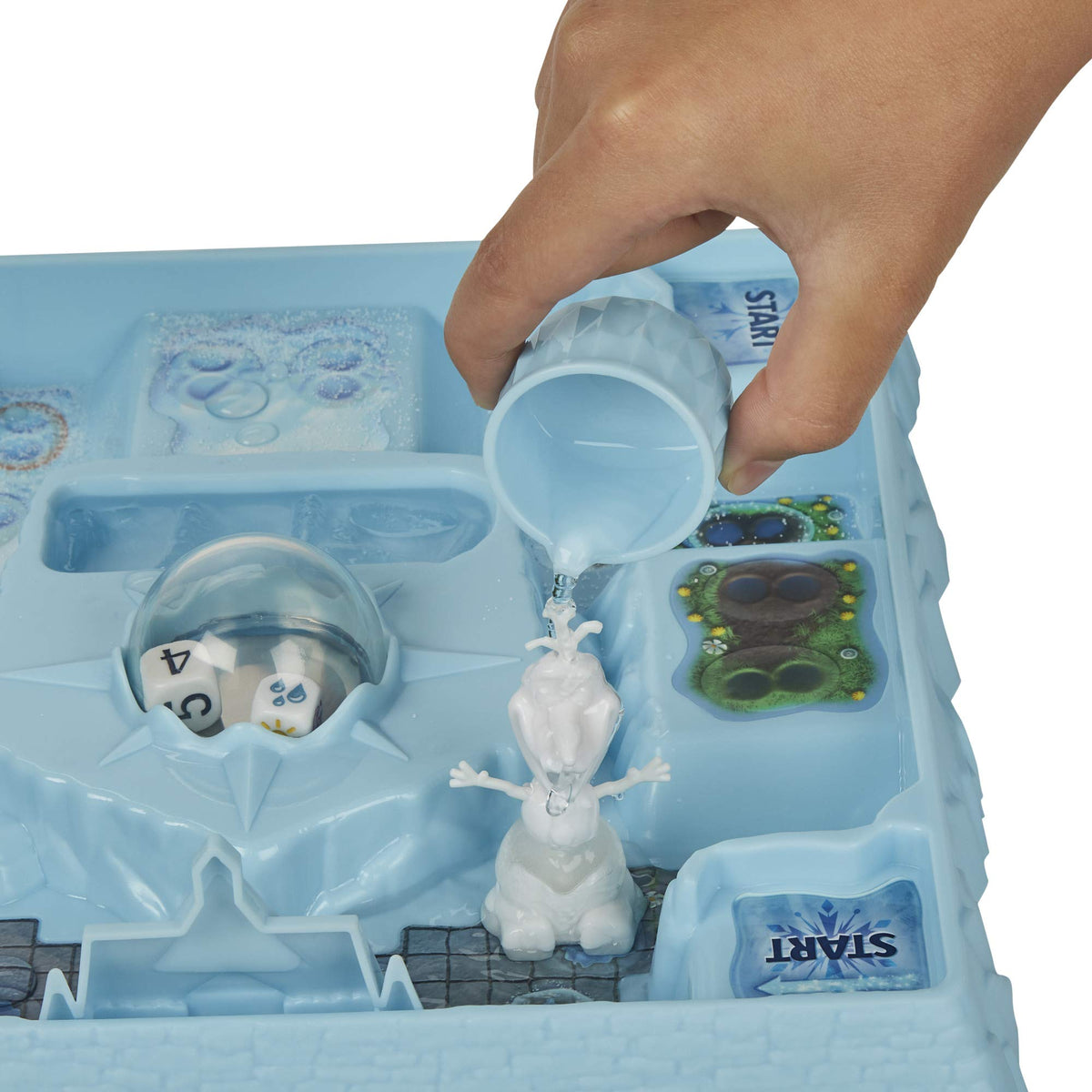 Hand pouring water from a small blue cup onto a white Olaf pawn's ice body