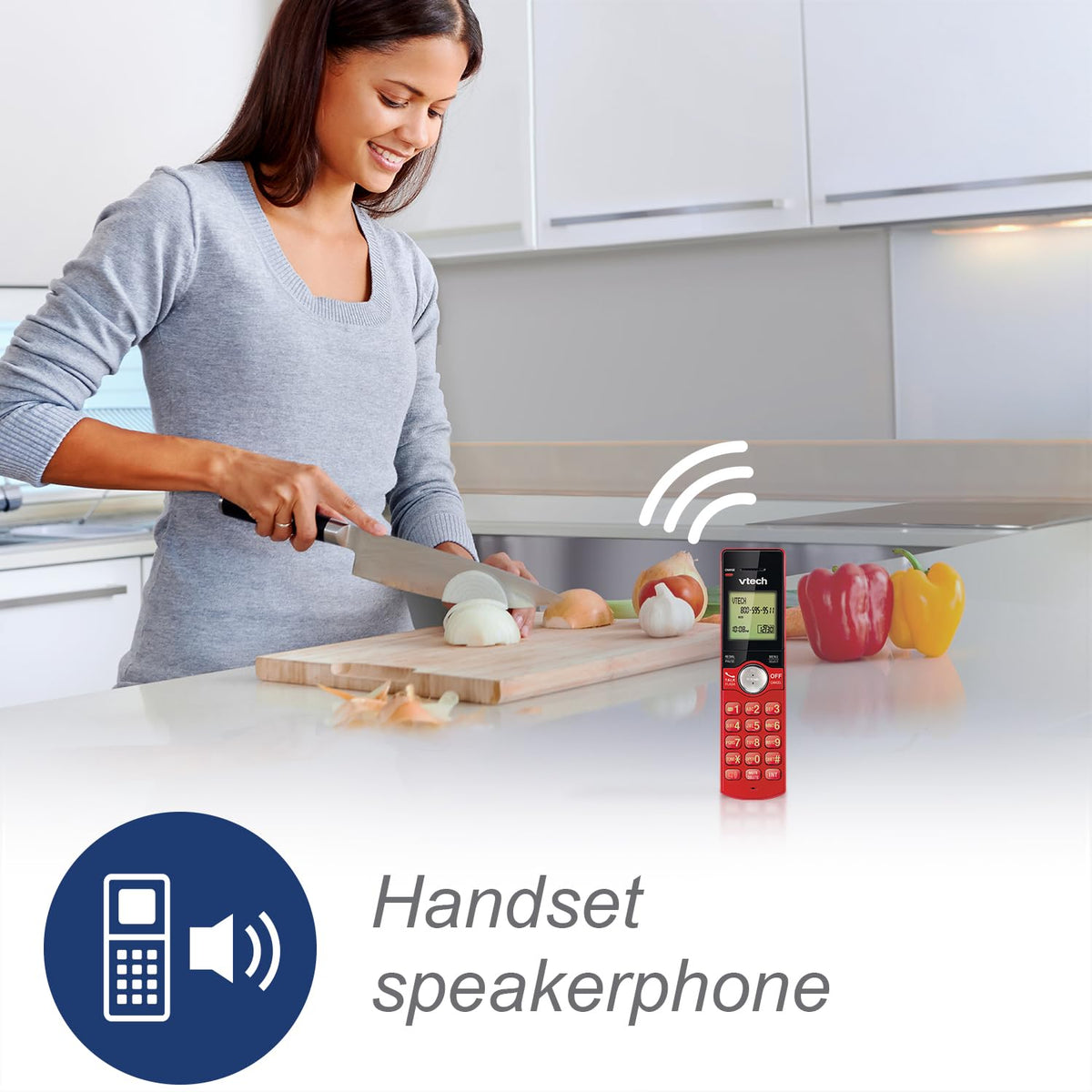 Woman chopping onions in a kitchen with the red handset on speaker beside her